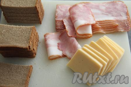 Кусочки чёрного хлеба разрезать на две части. Сыр нарезать на кусочки толщиной примерно 0,5 сантиметра.