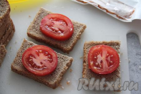 Хлеб нарезать на порционные кусочки. На каждый кусочек хлеба выложить кружочек помидора.