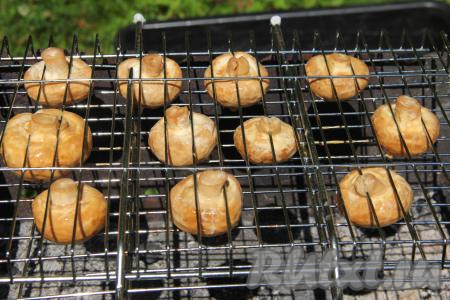 Выложить грибы, замаринованные в соевом соусе и майонезе, на решётку и поместить на мангал. Жарить шампиньоны без прямого огня, только на седых углях, без сильного жара.