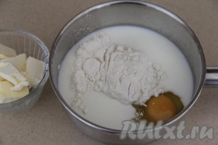Теперь займёмся приготовлением заварного крема. В его состав входит сливочное масло, его из холодильника нужно достать заранее, чтобы оно успело согреться до комнатной температуры и стать мягким. В кастрюлю, в которой будете варить крем, нужно влить молоко, добавить сырое яйцо, муку и 100 грамм сахара. 