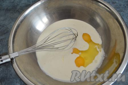 Затем в миску со смесью сметаны и соды вбить 3 сырых яйца, перемешать венчиком.