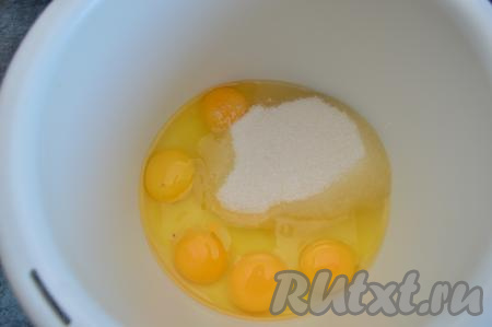 В чашу миксера вбейте сырые яйца и всыпьте сахар.