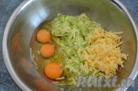 Сыр натереть на крупной тёрке. К кабачковой массе, отжатой от сока, добавить сырые яйца и половину натёртого сыра, тщательно перемешать (до однородности).