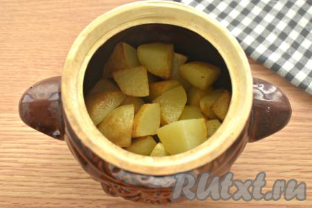 Обжаренный картофель перекладываем в горшочек вместе с маслом.