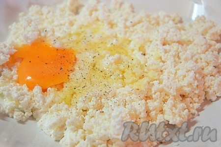 Творог размять вилкой, добавить яйцо, соль, черный перец, пропущенный через пресс чеснок и тщательно перемешать.