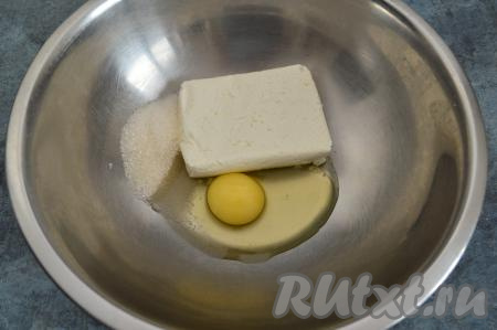 В миску всыпать сахар, выложить творог, добавить сырое яйцо.