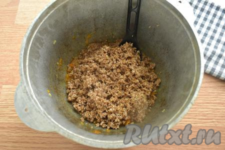 Затем добавляем к тушёнке с овощами промытую пшеничную крупу, солим (добавляя соль, учитываем степень солёности тушёнки), перчим, перемешиваем.