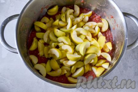 500 грамм нарезанных яблок добавьте в кастрюлю с томатной массой, перемешайте и поставьте на огонь.