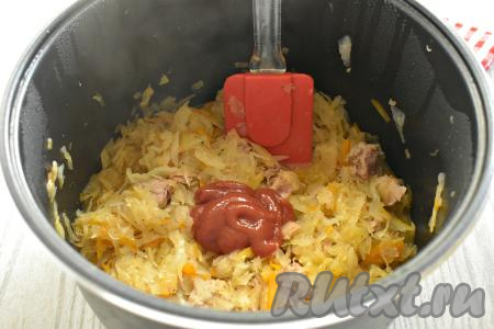 Через 10 минут к капусте с тушёнкой добавляем томатный соус и перемешиваем.