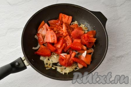 К обжаренному луку добавьте нарезанные помидоры.
