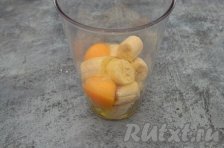 В чашу погружного блендера (или в измельчитель) выложить бананы, очищенные от кожуры и поломанные на крупные кусочки, вбить сырые яйца.