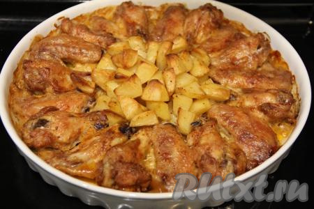 Поставить форму с куриными крылышками и картошкой в разогретую духовку и запекать 1 час при температуре 180 градусов.