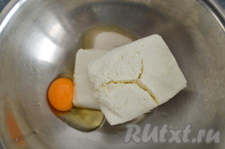Пока обсыхает изюм, займёмся тестом для сырников. Для этого в объёмной миске нужно соединить сахар, сырое яйцо и творог.