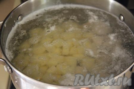 В кастрюлю с куриным мясом выложить картошку, дать бульону закипеть, а затем, уменьшив огонь, варить 10 минут.