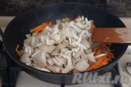 Добавить вешенки в сковороду с луком, обжаренным с морковью, перемешать. Обжаривать овощи с грибами 2-3 минуты, иногда помешивая.