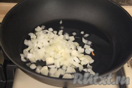 В сковороду влить растительное масло, дать ему разогреться, уменьшить до среднего огонь. Затем выложить в сковороду мелко нарезанный лук и обжаривать его до прозрачности (в течение 4-5 минут), иногда помешивая.