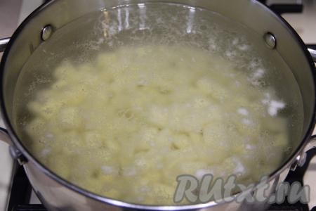 В кастрюлю влить 2 литра воды, поставить на огонь. В закипевшую воду выложить картошку, нарезанную на средние кубики, дать снова воде закипеть. А затем варить картофель на небольшом огне 15 минут.