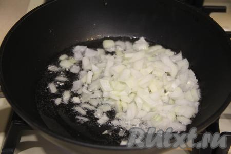 В сковороду с высоким бортиком влить масло, прогреть и выложить мелко нарезанную луковицу. Обжарить лук в течение 5 минут (до золотистого цвета), иногда помешивая, на среднем огне.