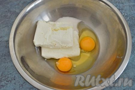 Пока изюм замачивается, можно заняться тестом для творожной запеканки. Для этого в глубокой миске нужно соединить сахар, яйца и творог.