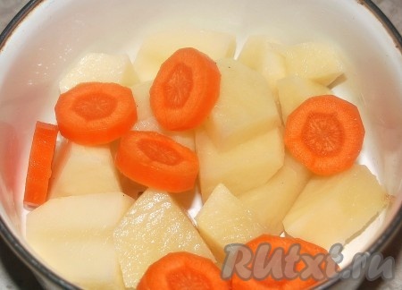 Затем добавить крупно нарезанные картофель и морковь. Варить 15 минут после закипания.
