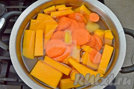 В кастрюлю с бульоном выложить нарезанные тыкву, картошку и морковь, поставить на огонь.