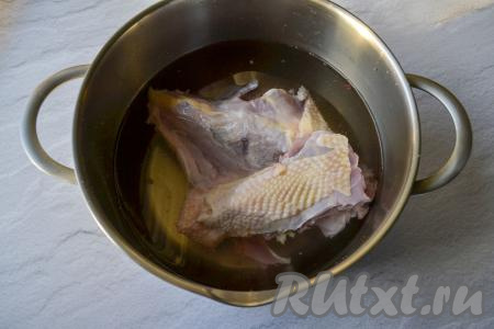 Вымойте части курицы на кости, выложите в кастрюлю, залейте 1,5 литрами холодной воды, поставьте на огонь.