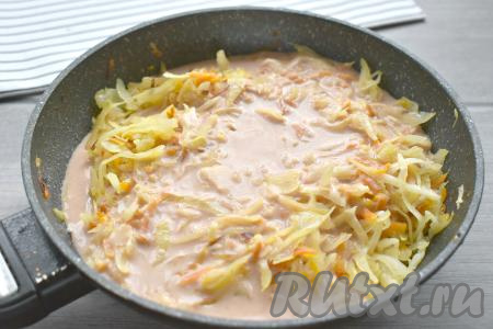 Соус из сметаны и томатной пасты переливаем к жареной капусте на сковороду.