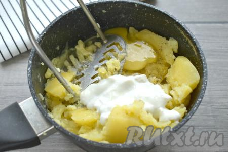 Даём картошке остыть в течение нескольких минут, а затем добавляем к ней сметану и сырое яйцо, начинаем разминать толкушкой до получения пюре, солим и перчим.