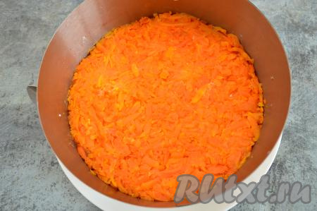 На крупной тёрке натереть морковку и сформировать из неё следующий слой салата "Мимоза", немного присолить, утрамбовать.
