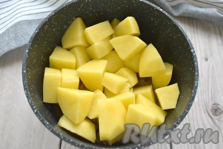 Затем к овощам с сердечками выкладываем очищенный картофель, нарезанный на крупные кубики.