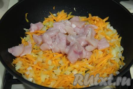 Нарезать куриное филе на кубики размером 1 на 1 сантиметр, выложить в сковороду с обжаренными овощами, перемешать.