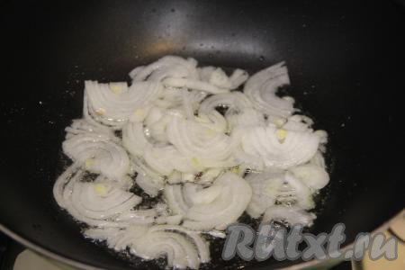 Одновременно с подготовкой фунчозы, можно заняться обжаркой овощей. Для этого в сковороду с высокими бортиками (или в сковороду вок) нужно влить растительное масло, разогреть его и выложить лук, нарезанный на полукольца. Обжарить лук до прозрачности (в течение 3-4 минут), иногда перемешивая, на среднем огне.