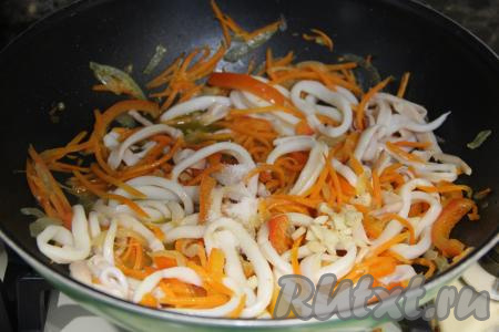 Сразу же добавить нарезанный чеснок, подсолить (добавляя соль, учитывайте, что в дальнейшем будет использоваться соевый соус), перемешать. Жарить кальмары с овощами 5 минут, периодически помешивая. 