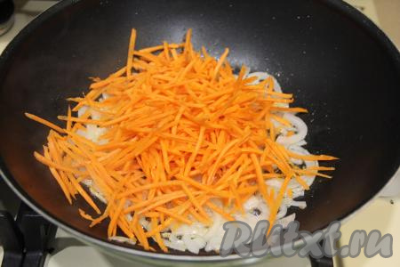 К луку, обжаренному до прозрачности, выложить морковку, натёртую на тёрке для моркови по-корейски (или на обычной крупной тёрке), перемешать и обжарить до мягкости моркови (минут 5), время от времени помешивая. 