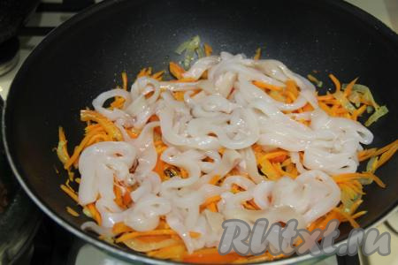 Добавить кальмары в сковороду к овощам.