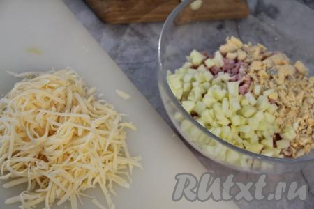 В салатнике соединить нарезанную колбасу и раскрошенные желтки. Яблоко очистить от кожуры, нарезать на мелкие кубики и тоже выложить в салатник. Сыр натереть на крупной тёрке.