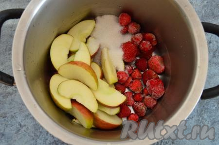В кастрюлю выложить замороженную клубнику, добавить яблоки, нарезанные на дольки, всыпать сахар.