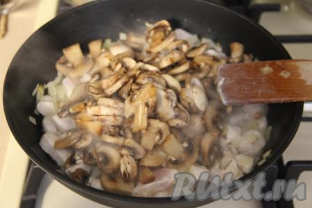 Добавить нарезанные грибы в сковороду, перемешать и жарить минут 15 (до выпаривания жидкости из грибов), не забывая время от времени помешивать.