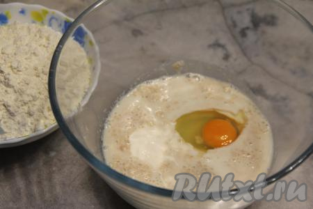 После того как опара запенится, перелить её в объёмную миску, добавить кефир комнатной температуры, яйцо, соль, оставшийся сахар, перемешать.