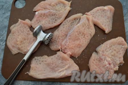 Куриное филе разрезать на кусочки толщиной 1,5-2 сантиметра и отбить с одной стороны кулинарным молоточком до толщины 0,5-0,8 сантиметра. Посолить мясо по вкусу, я солю только с одной стороны.