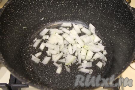 Теперь необходимо обжарить морковку и оставшуюся половину луковицы. Я взяла кастрюлю с толстым дном и обжаривала прямо в ней. В кастрюлю влить растительное масло, прогреть его. Оставшуюся половину луковицы мелко нарезать, выложить в прогревшееся масло. Если ваша кастрюля не позволяет обжаривать овощи, тогда обжарьте их на сковороде.