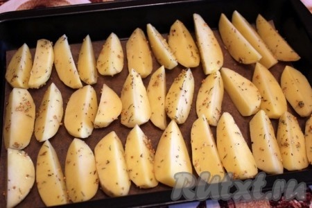 Поставьте противень с картофелем в разогретую духовку и запекайте при 200 градусах примерно пол часа.