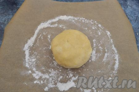 По прошествии получаса достать тесто для галеты из холодильника. Пекарскую бумагу немного припылить мукой. Выложить в середину колобок теста.