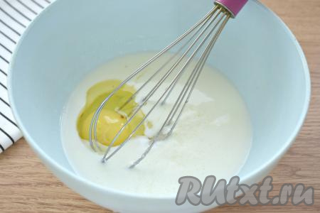 Переливаем кефир комнатной температуры в объёмную миску, вбиваем яйцо, вливаем растительное масло, добавляем сахар и щепотку соли. Если вы добавите 2 столовых ложки сахара, то выпечка получится не очень сладкой, но при подаче вы сможете полить по вкусу мёдом или сгущёнкой, регулируя сладость по своему вкусу. Если добавите 3 столовых ложки сахара, то панкейки получатся достаточно сладкими. 