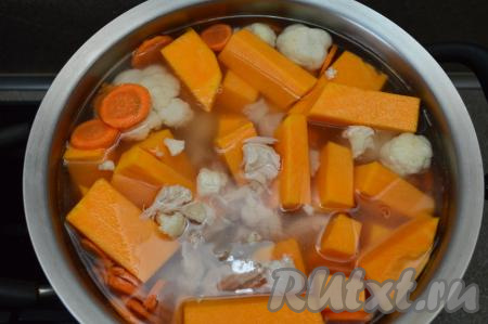 В кастрюлю с закипевшим бульоном выложить картошку, тыкву, морковку, цветную капусту, посолить, ещё раз дать закипеть и уменьшить огонь.
