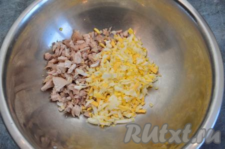 Заранее следует отварить куриное филе и яйца. Куриное филе варим в подсоленной воде примерно 25 минут с момента закипания воды. Яйца варим 10 минут после начала кипения воды. Варёному мясу и яйцам дать полностью остыть. Куриное филе нарезать на небольшие кусочки. Яйца очистить и натереть на крупной тёрке. Сложить натёртые яйца и нарезанную курицу в глубокую миску.