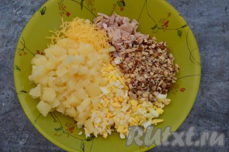 Выложить порубленные орехи в тарелку с салатом из ананасов и курицы.