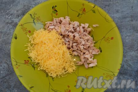 Остывшее куриное филе нарезать на небольшие кусочки, переложить в глубокую тарелку, добавить сыр, натёртый на мелкой тёрке.