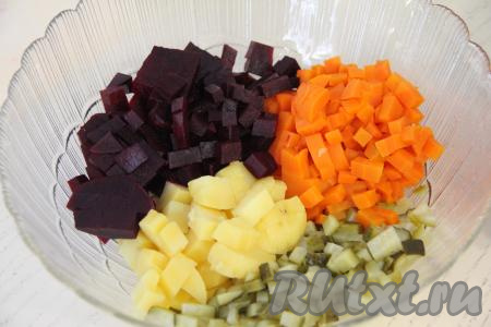 Свеклу, морковь и картошку очистить от кожуры, нарезать на средние кубики, сложить в салатник. Сюда же выложить огурцы, нарезанные на средние кубики.