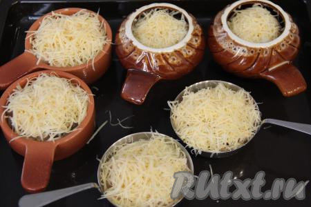 В кокотницы поверх жульена разложить сыр, натёртый на крупной тёрке. Переставить кокотницы на противень и поместить в разогретую духовку. 